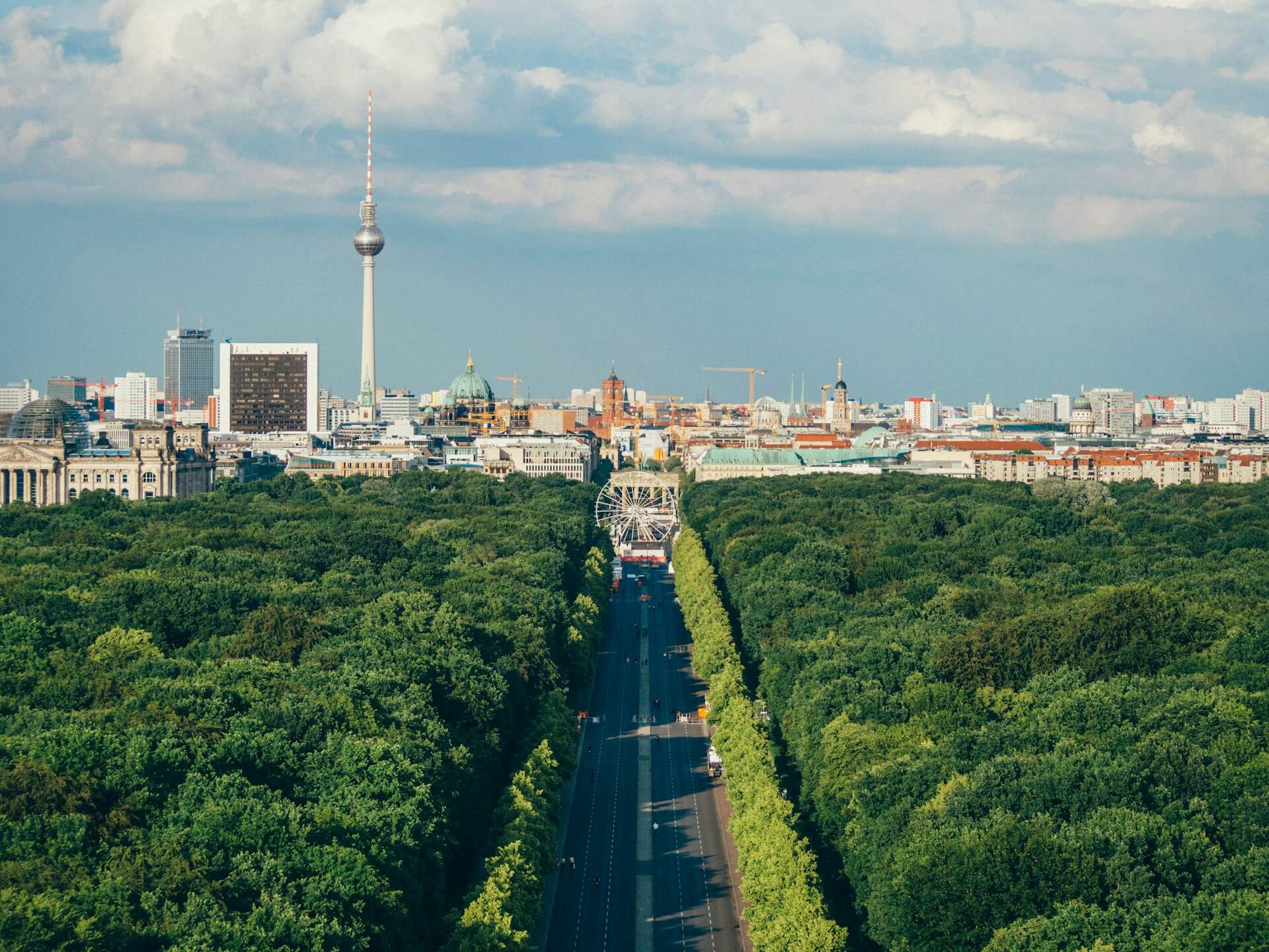 Foto von Berlin mit Tiergarten im Vordergrund und Brandenburger Tor sowie Fernsehtrum im Hintergrund